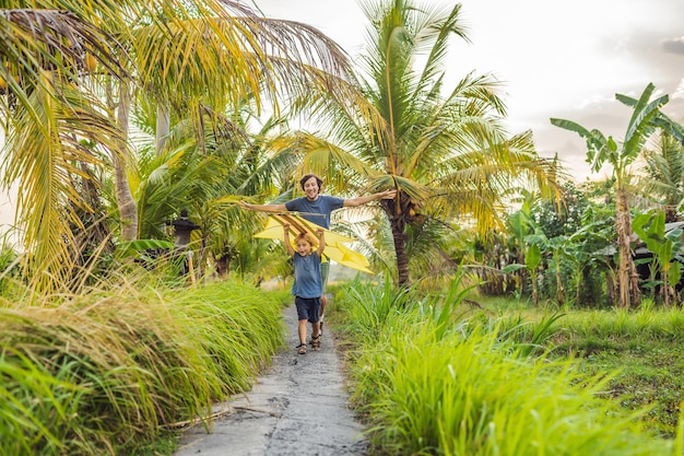 Papá e hijo lanzan una cometa en un campo de arroz en la isla de Ubud, Bali, Indonesia