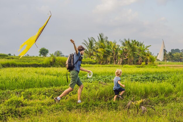 Papá e hijo lanzan una cometa en un campo de arroz en Ubud, isla de Bali, Indonesia