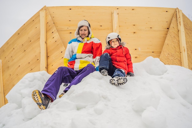 Papá e hijo en una montaña nevada en una estación de esquí