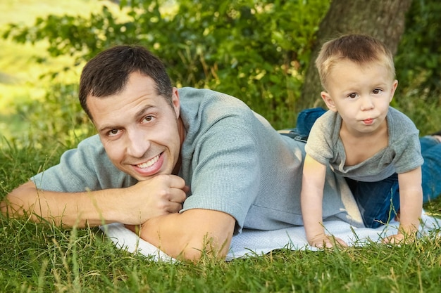 Papá e hijo en la naturaleza jugando en el parque en el césped