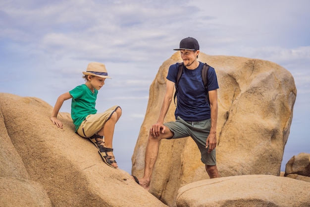 Papá e hijo en una roca Concepto de vacaciones domésticas