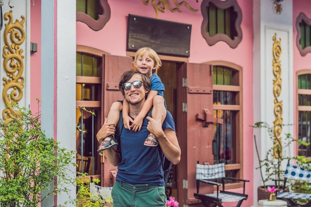 Papá e hijo son turistas en la calle en el estilo portugués romani en la ciudad de phuket, también llamado