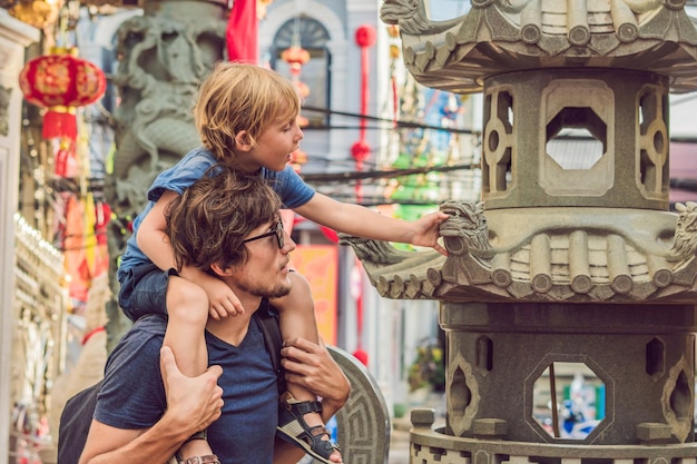 Papá e hijo son turistas en la calle romaní de estilo portugués en la ciudad de Phuket. También se llama Chinatown o el casco antiguo. Viajar con el concepto de niños