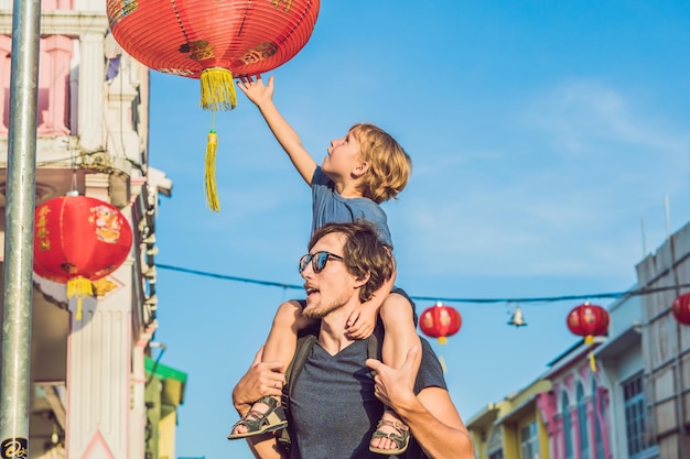 Papá e hijo son turistas en la calle romaní de estilo portugués en la ciudad de Phuket. También se llama Chinatown o el casco antiguo. Viajar con el concepto de niños