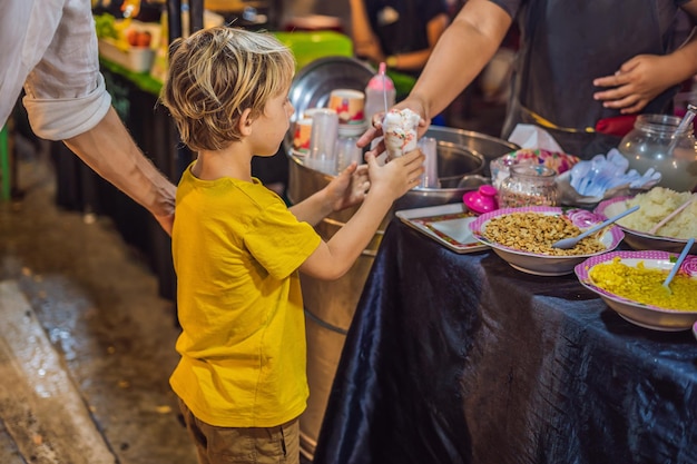 Papá e hijo son turistas en el mercado de comida asiática de Walking Street