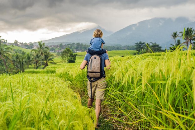 Papá e hijo viajan en las hermosas terrazas de arroz de Jatiluwih con el telón de fondo de los famosos volcanes en Bali, Indonesia Viajar con el concepto de niños