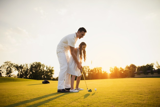 Papá le enseña al niño a tomar un hobby de golf.