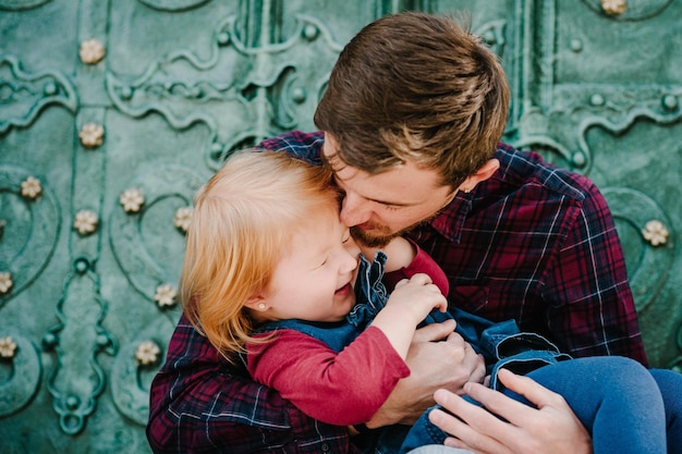 Foto papá de familia feliz abraza y besa a su hija disfrutando del tiempo juntos primer plano