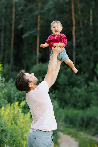 Papá feliz divirtiéndose con su pequeño hijo tirándolo