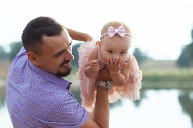 Papá feliz juega con su hijita a dar un paseo Paternidad