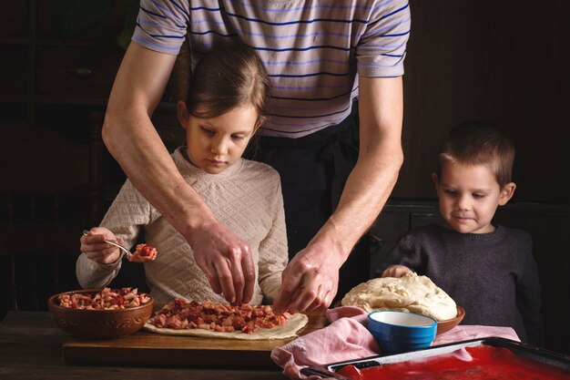 Papá con hijos prepara un postre