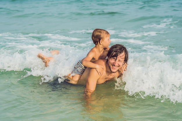 Papá juega con su hijo en el mar