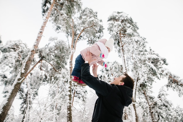 Papá jugando con su hija en Winter Forest Park.