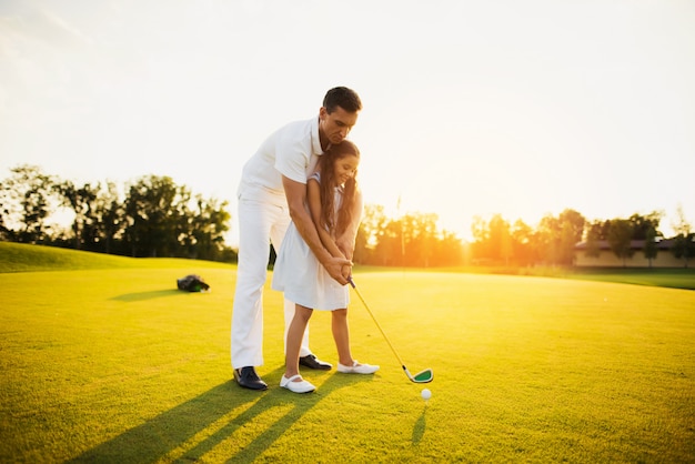 Papa lehrt Kind nehmen Schuss Golf Familie Hobby.