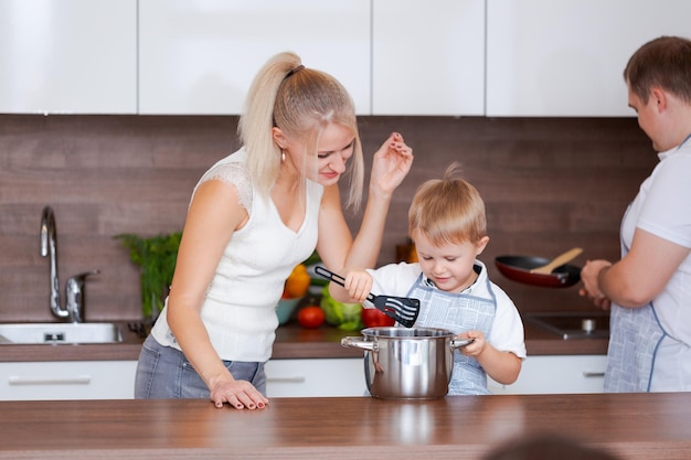 Papá mamá y su pequeño hijo están preparando la cena Familia feliz preparándose