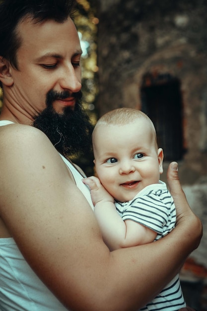 Papa mit Baby im Arm vor dem Hintergrund von Seifenblasen und einem alten Schloss