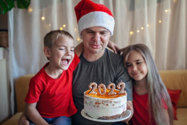 Papa mit Kindern vor Weihnachtskuchen mit Zahlenfamilie Neujahrsfeier festlichen Hintergrund