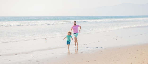 Papa mit kleinem Jungen im Meer. Familientag am Wochenende. vater und kind haben spaß im freien. Vater und Sohn laufen am Sommerstrand. familienreisewochenende und urlaub. Kindheit und Erziehung.