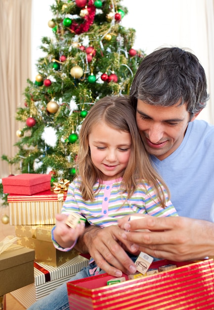 Papá y niña jugando con regalos de navidad