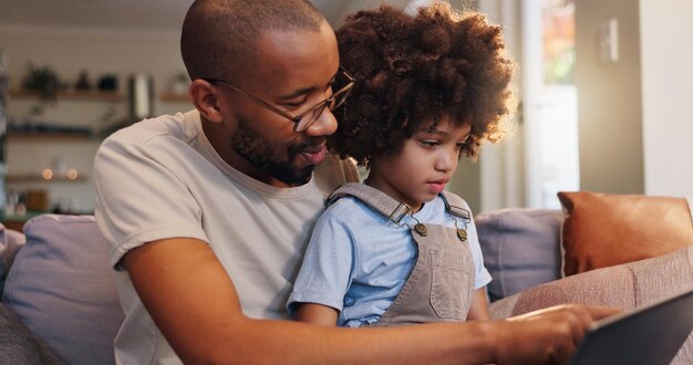 Papá y niño en casa en una tableta para vincular libros electrónicos y transmitir en línea para películas, dibujos animados o video Descarga de tecnología o padre soltero con niño o pantalla táctil para el desarrollo del aprendizaje