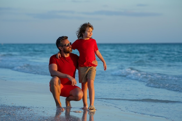 Papá y niño hijo abrazándose en la playa a la hora del día feliz familia día del padre amor familia padre y