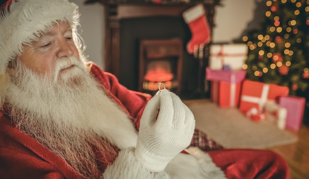 Papá noel con anillo de compromiso en casa en la sala de estar