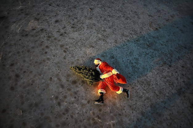 Papá Noel se apresura a recibir el Año Nuevo con regalos y árbol de Navidad Papá Noel en patines de hielo va a Navidad