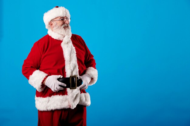 Papá Noel con los brazos cruzados sobre un fondo azul.