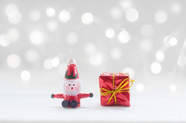 Foto papá noel y caja de regalo roja con luz brillante para el fondo de la decoración de navidad