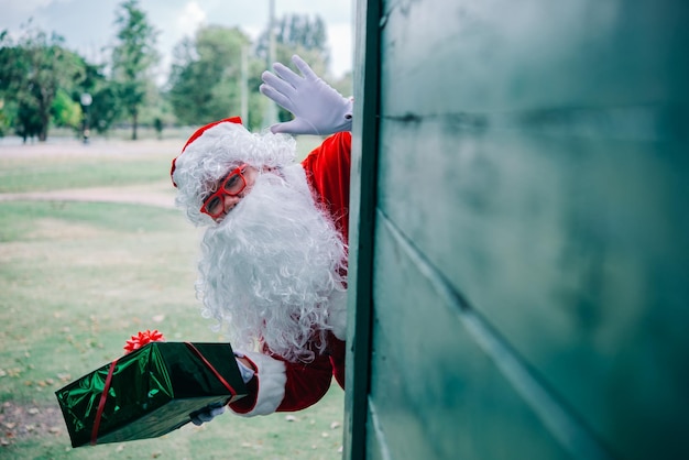 Papá noel con caja de regalo sobre fondo de maderaGente de TailandiaEnvió felicidad para los niñosFeliz NavidadBienvenido al invierno