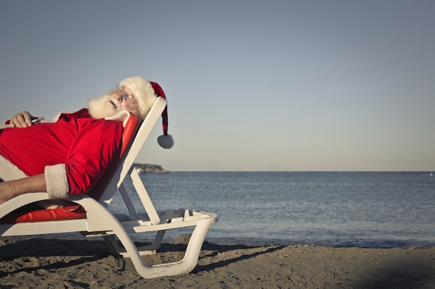 Foto papá noel descansando en la playa