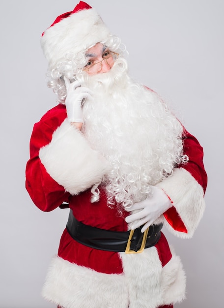 Foto papá noel divertido en un traje rojo con un teléfono