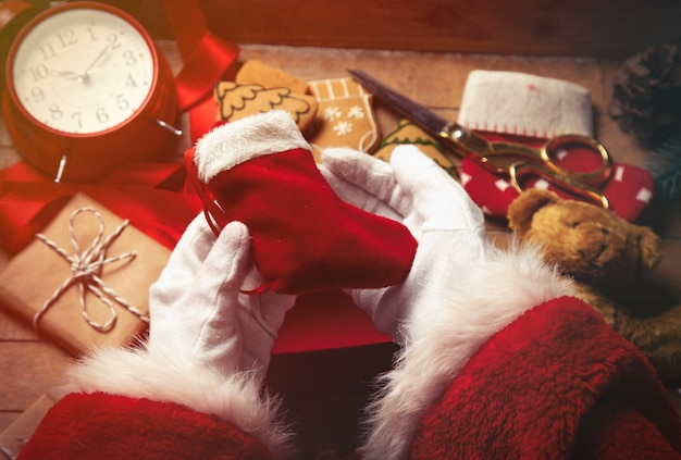 Papá Noel envolviendo regalos de Navidad y galletas