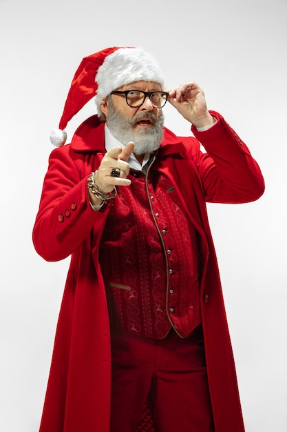 Papá Noel con estilo moderno en traje rojo de moda aislado sobre fondo blanco.