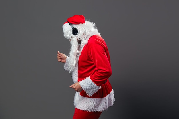 Papá Noel con una larga barba blanca y gafas de sol y auriculares.