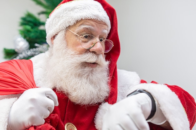 Papá Noel llega tarde. Se ve asustado por el reloj. Papá Noel lleva un reloj moderno. Cuenta regresiva. El tiempo está llegando.