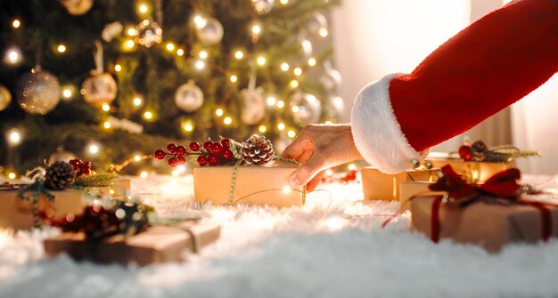 Papá Noel lleva regalos de Navidad bajo el árbol