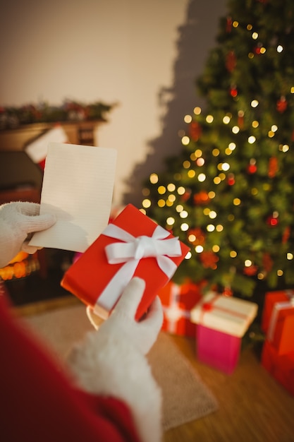 Papá Noel con papel y regalo