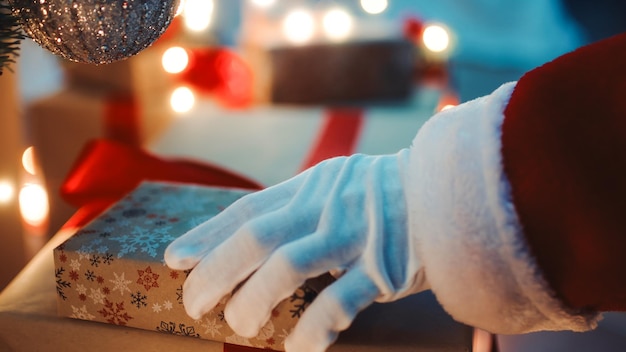 Papá Noel posa regalos debajo del árbol