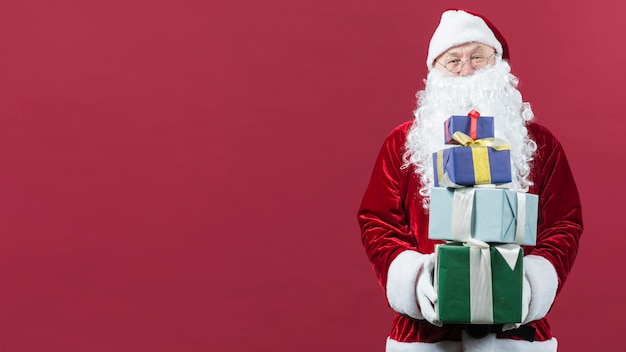 Foto papá noel con regalos coloridos en las manos