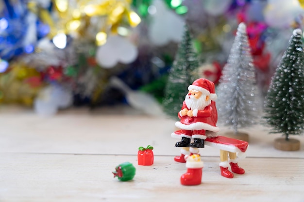 Papá Noel sentado en un banco rojo con regalos en previsión del festival divertido y feliz.