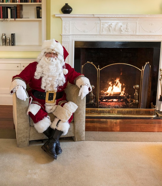 Foto papá noel sonriente junto a la chimenea