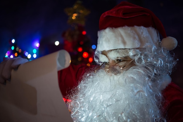 Papá Noel sosteniendo papel y leyéndoloFeliz NavidadFelicidad para los niñosBienvenido al inviernoFeliz año nuevo