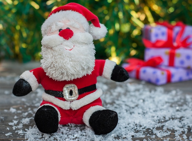 Papá Noel en una superficie de madera gris con nieve