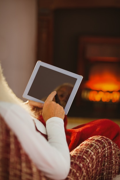 Foto papá noel tocando la tableta digital