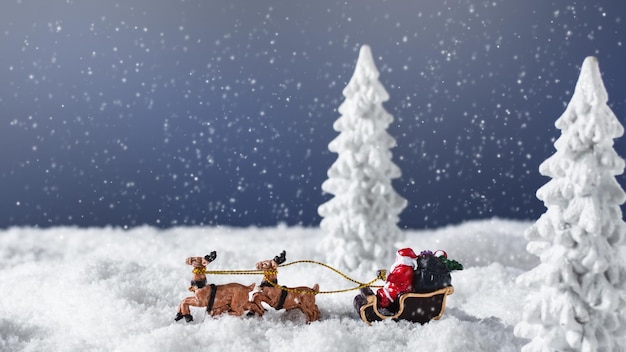 Papá Noel en un trineo con renos en el bosque nevado