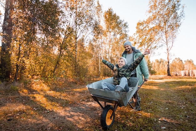 Papá pasa tiempo con su hijo, un niño feliz empujado por un papá