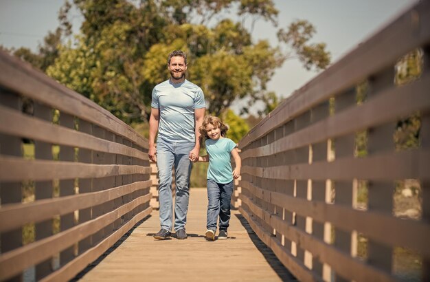 Papá soltero sonriente que lleva a un niño pequeño fuera de la amistad