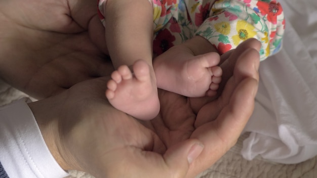 Papá sosteniendo los pies del bebé en las manos