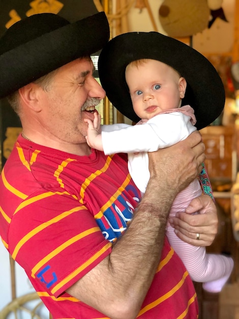 Foto papá sosteniendo a su hija con una sonrisa